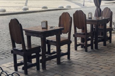 İnsanlar olmadan eski tarz bir sokak kafesinde ahşap masa ve sandalyeler.