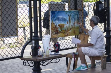 Kiev, Ukrayna - 28 Temmuz 2019: Sanatçı Andreevsky descent Caddesi 'nde resim çiziyor