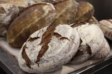 Toplu taze pişmiş çörekler ve Pazar tezgahın üzerine loafs. Ekmek üretimi