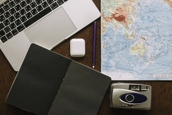 Composition with map of the world, vintage camera and laptop