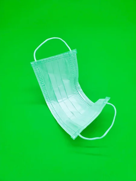 Medical mask, prevention of influenza. Protective mask for health care use on green background. medical health care object