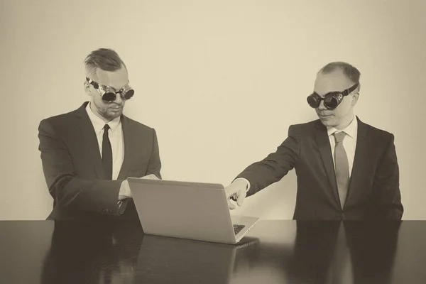 Twee zakenman achter het bureau zit — Stockfoto