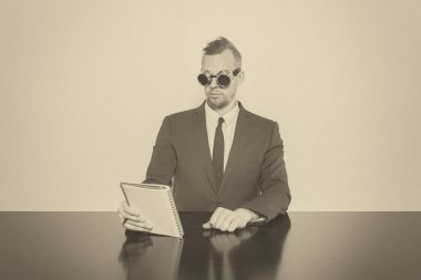 Not Defteri ile ofis masa başında oturan işadamı