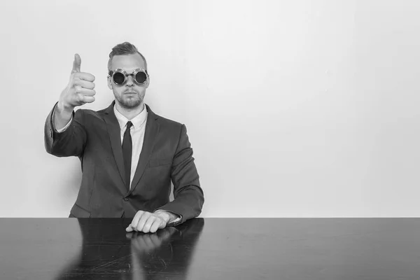 Geschäftsmann sitzt mit Fernglas am Schreibtisch — Stockfoto