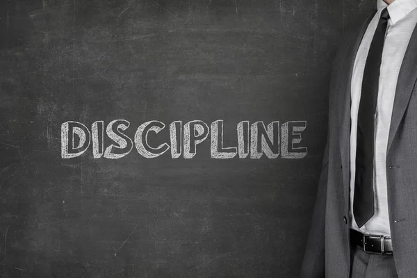Empresário em pé por Disciplina Texto no quadro negro — Fotografia de Stock