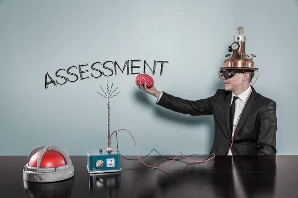Businessman In Futuristic Helmet Holding Brain By Assessment Text — Stock Photo, Image