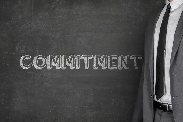 Businessman Standing By Commitment Text On Blackboard — Stock Photo, Image
