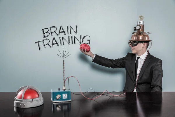 Businessman Wearing Helmet Holding Brain While Sitting By Text — Stock Photo, Image