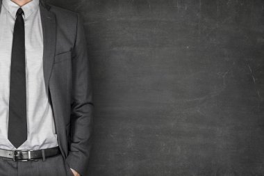 Blackboard karşı cebinde el ile ayakta işadamı