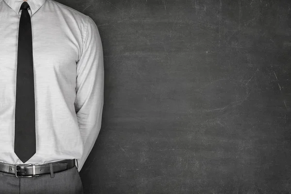 Businessman Standing With Hand Behind Back Against Blackboard — Stock Photo, Image