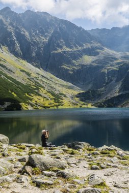 Zakopane, Polonya - 01 Eylül 2016: Adam göl çevresindeki tepeler üzerinde dürbün bakar