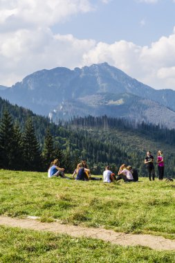 Zakopane, Polonya - 13 Eylül 2016: Kızlar kampında dağlarda bir açıklıkta gitar çalmak