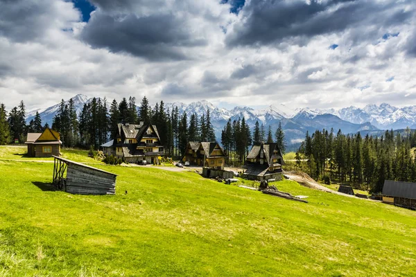 Case di montagna in radura con una splendida vista sulle montagne . — Foto Stock
