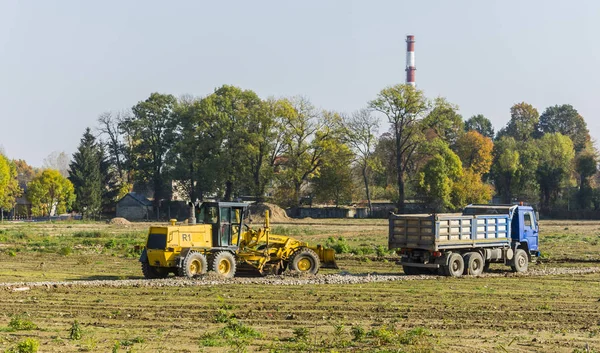 Grader en vrachtwagen op de bouwplaats. — Stockfoto