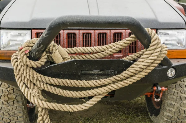 Tow rope suspended on bumper of car.
