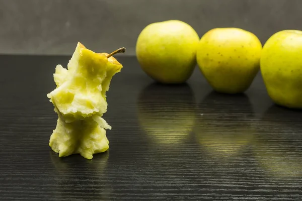 Apple core and apples in the background.