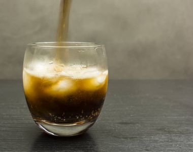 Bir cola içecek bir bardak buz küpleri ile içine döktü.