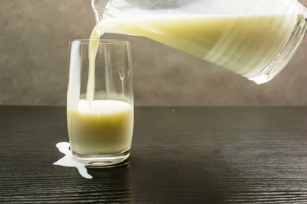 Gemorste melk tijdens het gieten in een glas. — Stockfoto