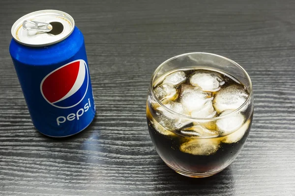 Стекло с освежающим безалкогольным напитком (Pepsi) с кубиками льда на столе . — стоковое фото