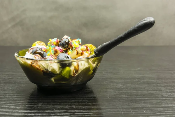 Una cucharadita inmersa en un tazón con postre de helado . — Foto de Stock