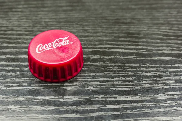 Tampa vermelha de Coca-Cola em uma mesa de madeira . — Fotografia de Stock