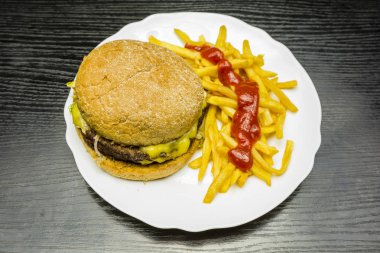 Hamburger, patates kızartması ve ketçap ile bir tabak.