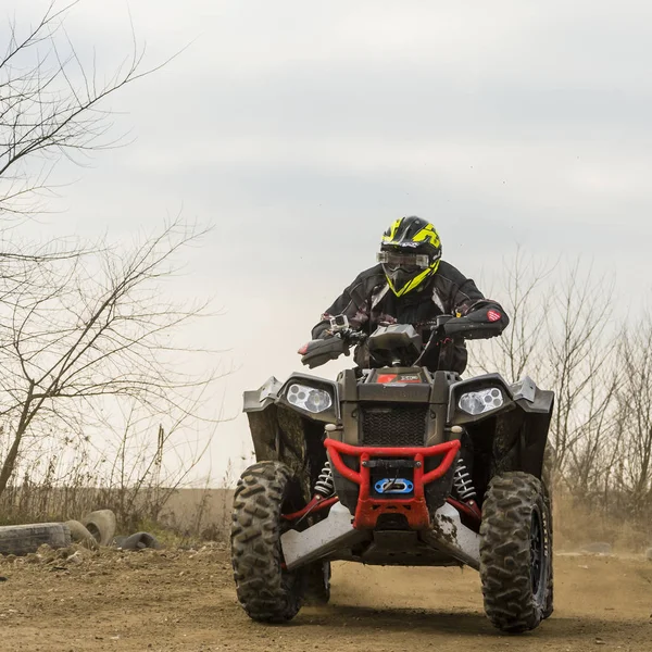 Un hombre montando ATV en ropa protectora y un casco . — Foto de Stock