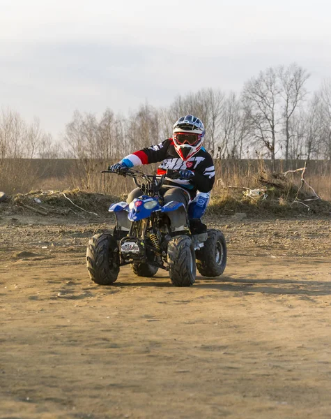 Jonge bedreven stuurwiel op een kleine quad. — Stockfoto