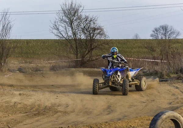 All-terrain vehicle racer takes a turn during a race on a dusty terrain. — Stock Photo, Image