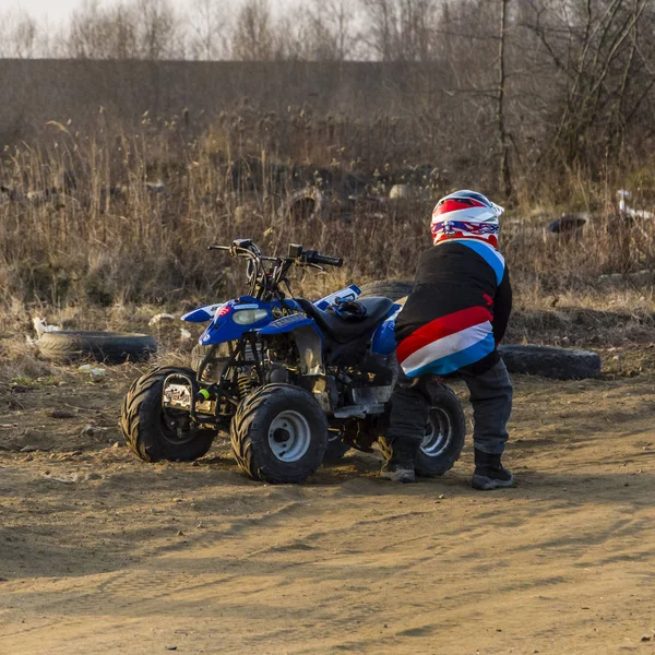 A small boy and his quad which has broken down. — Stock Photo, Image