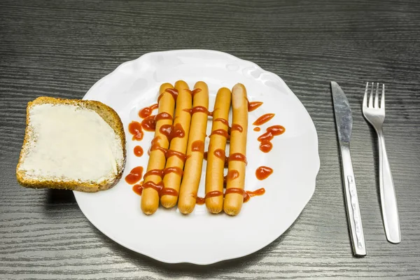 Un plato de salchichas hervidas con ketchup . —  Fotos de Stock