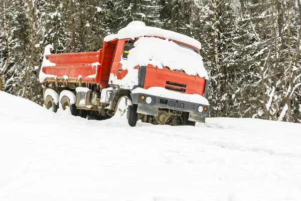 Ein roter LKW, der im Winter in der Nähe des Waldes abgestellt wurde — Stockfoto