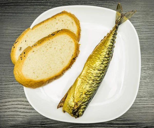 Białe płytki z wędzonej makreli z golden skóry i kromki chleba. — Zdjęcie stockowe