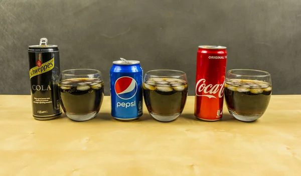 Bir cola içecek üreticilerden listeleme: Pepsi, Coca-Cola ve Schweppes. Gözlük buz küpleri ile sunulan cola. — Stok fotoğraf