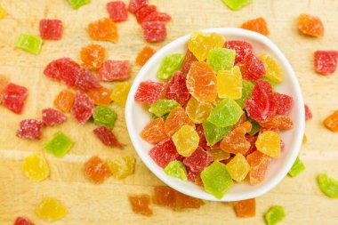 Renkli beyaz bir kase ananas şekerlenmiş ve ahşap bir üste döktüm. Yukarıdan görüntülemek.