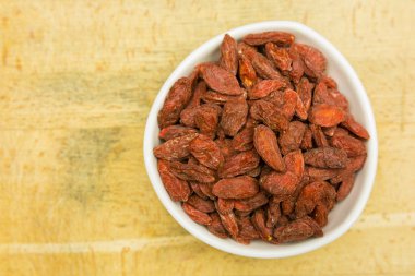 Goji meyveleri bir ahşap tahta üzerinde kurumuş. Yukarıdan görüntülemek.