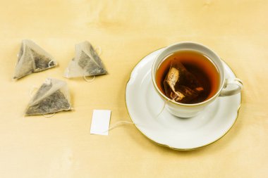 Masada bir bardak taze demlenmiş çay bir çanta.