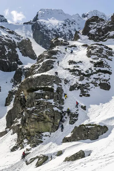 Studenti pod dohledem instruktora na zimní horolezectví kurz učí, jak bezpečně chodit v zimě v horách. — Stock fotografie