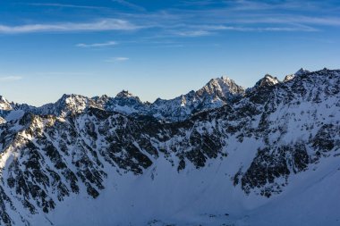 Kış dağı manzarası. Güneşin batışıyla aydınlanan tepeler.