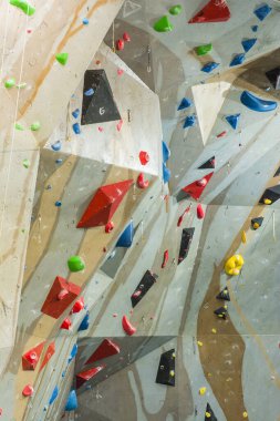 Tarnow, Polonya - 28 Temmuz 2019: Spor salonunda duvara tırmanmak. Çeşitli zorluklarla dolu bir tırmanış yolu oluşturan bir dizide renkli tutuş.