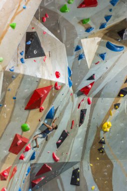 Tarnow, Polonya - 28 Temmuz 2019: tırmanma duvarına tırmanıyor. Sporcu hafif bir asılma formasyonuna tırmanıyor..