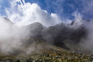 Sonbahar manzarasında dağ manzarası. Bulutlar tepe ve vadi boyunca akıyor..
