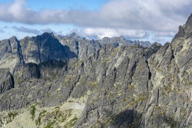 Yaz mevsiminde kayalık dağ sırtlarının manzarası, üzerinde kara bulutlar yaklaşıyor..