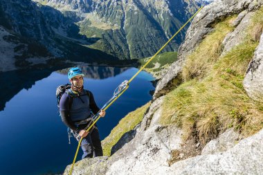 Bukowina Tatrzanska, Polonya - 15 Eylül 2019: Daha zorlu bir yoldan dağcıyı aşağı itin. Arka planda vadide bir göl.