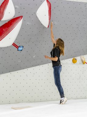 Zakopane, Polonya - 06 Eylül 2019: Bir kaya yarışmasında genç bir gönüllü tırmanma duvarına tutundu.