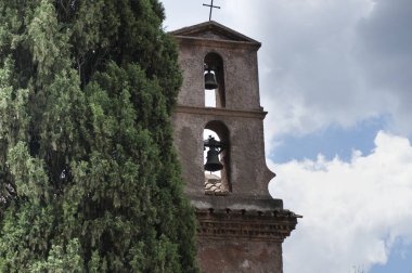 Servi ağacının yanındaki çan kulesi