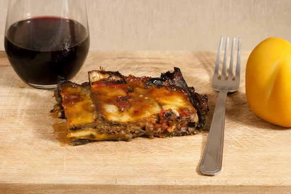 delicious eggplant parmesan served on a wooden platter with wine and cheese