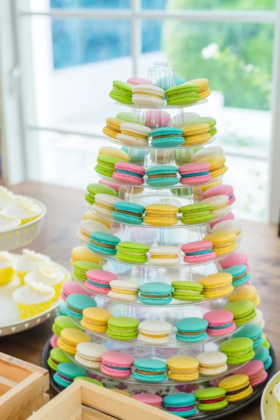 Kleurrijke macarons op piramide-vormige kunststof stand op partij — Stockfoto