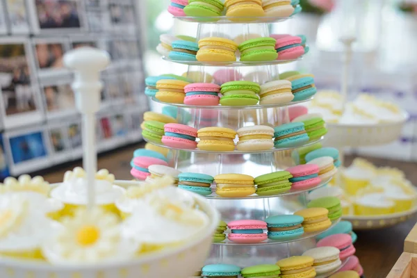 Colorful macarons on pyramid-shaped plastic stand at party — Stock Photo, Image