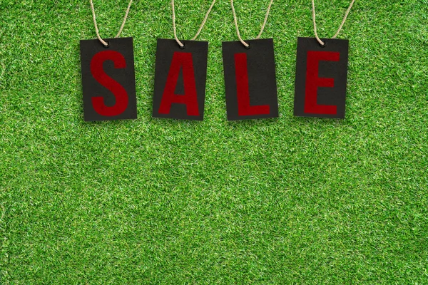 Verkaufsetiketten auf grünem Gras mit Kopierschutz — Stockfoto